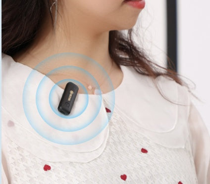 Clip-on BOYA radio microphone near neckline, black transmitter clip-on