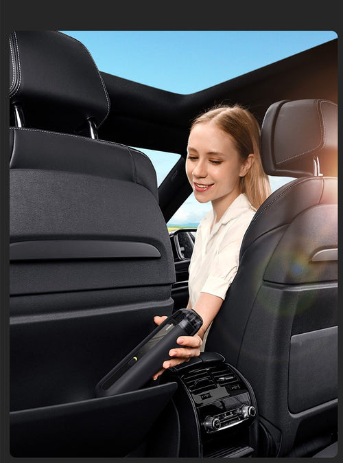 Handheld mini vacuum cleaner removing dust from a car seat cushion and crevice.