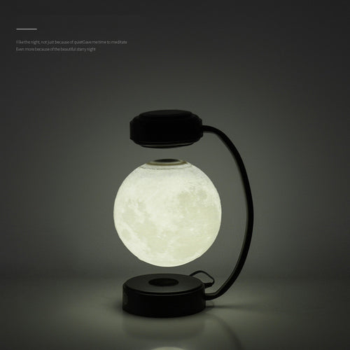 Black moon-shaped LED night light with glowing floating globe and curved base stand